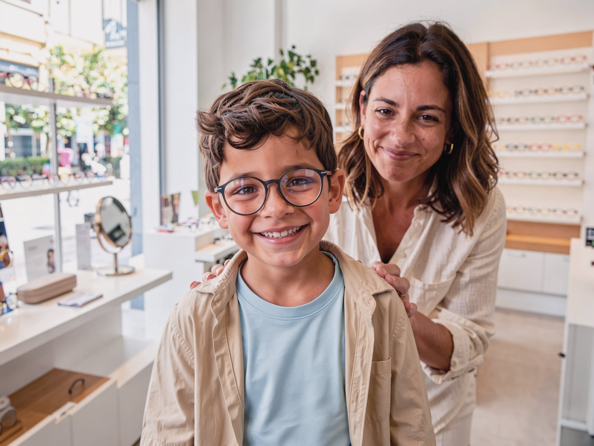 Niño con gafas nuevas sonriendo en la óptica